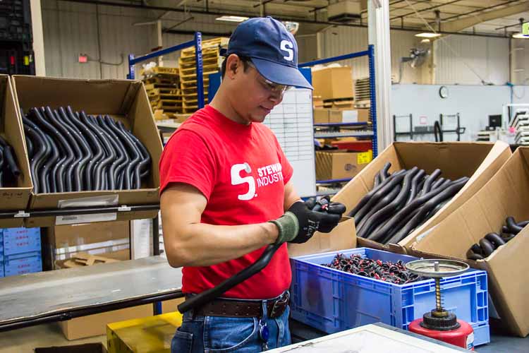 John Aung at work at Steward Industries. He is learning English in a class offered in the workplace.