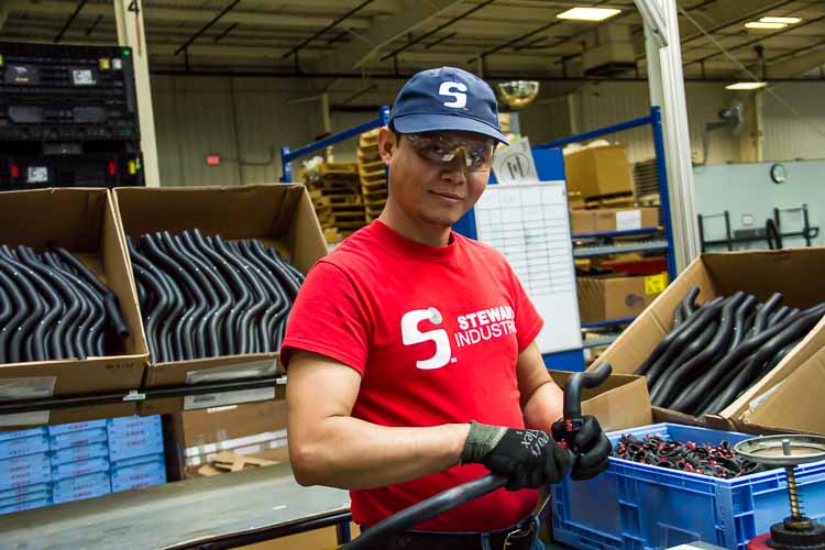 John Aung at work at Steward Industries. He is learning English in a class offered in the workplace.