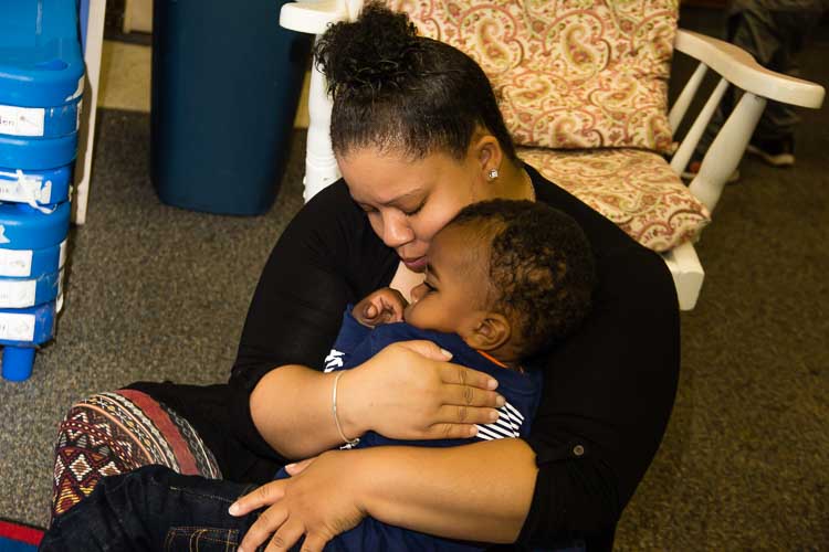 Miss Takyra Perkins cuddles a young child at Take-A-Break childcare.