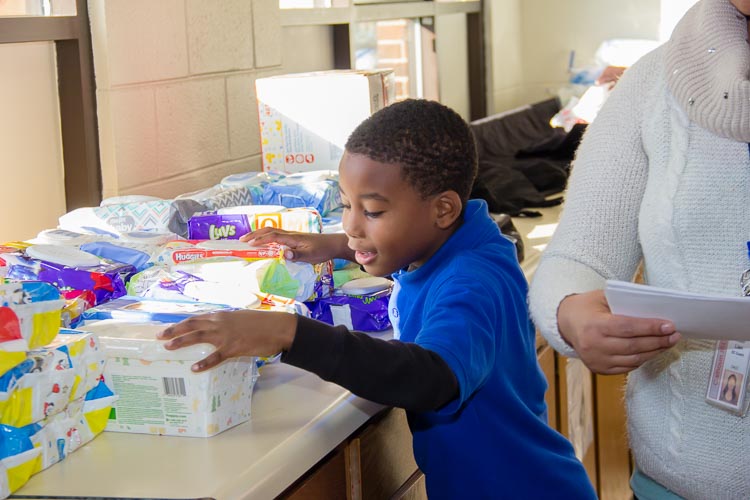 Joseph hands out sanitary wipes at recent diaper distribution. He was working toward a merit badge.