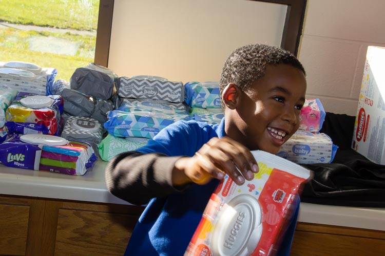 Joseph hands out sanitary wipes at recent diaper distribution. He was working toward a merit badge.