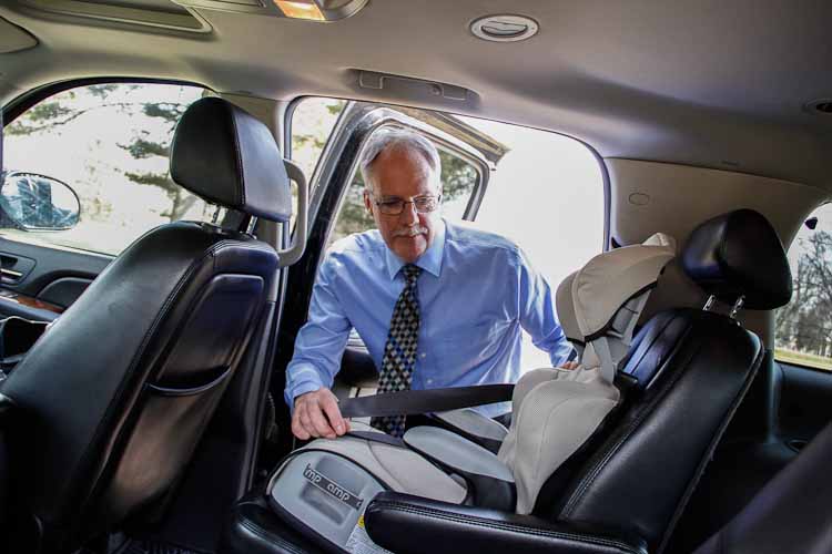 Driver Ken Moody placing child seat