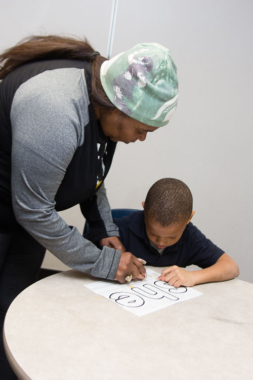 Classroom coach Ms. Jewel works with kindergarten and first graders in the New Genesis after school program.