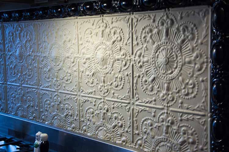 Decorative tile backsplash seen above the stove.