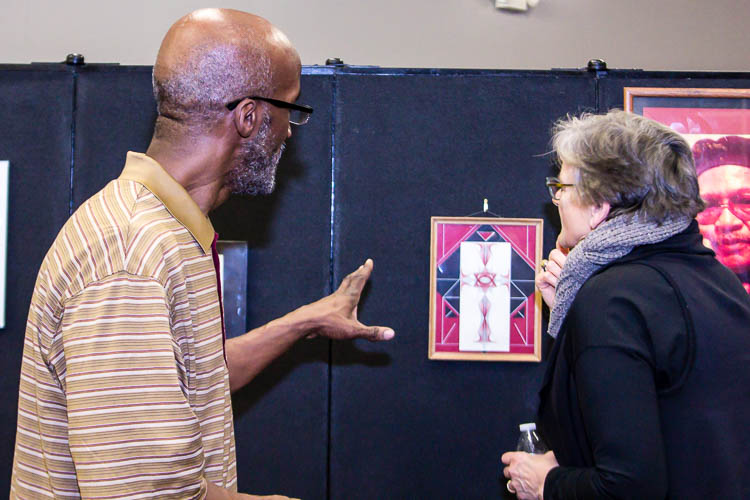 Thomas Woodruff, featured artist at the Northside Art Hop, discusses his work with patrons.