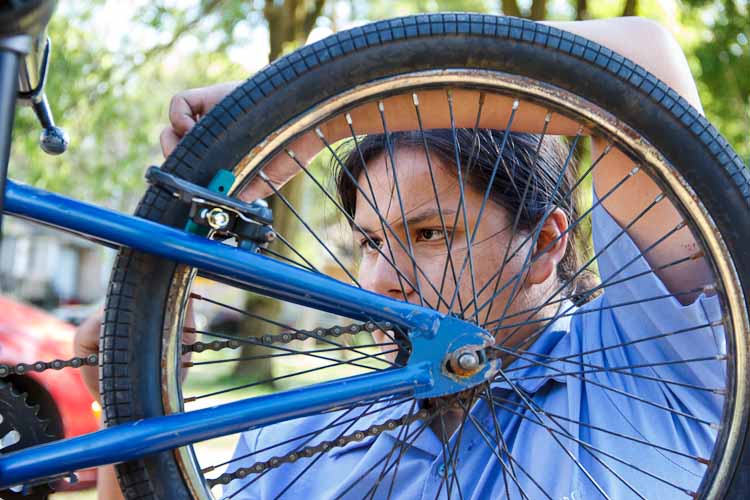 Mijiikwis Wabanimkee works on a bike