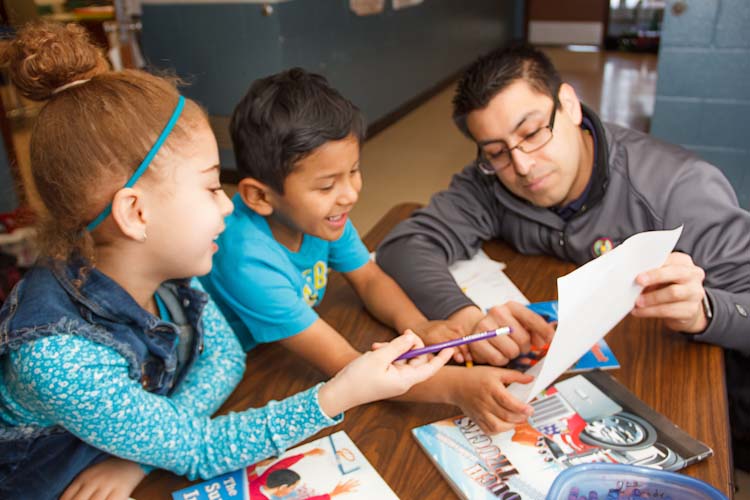 Israel Flores with reading buddies Tori and Joel  Photo by Susan Andress