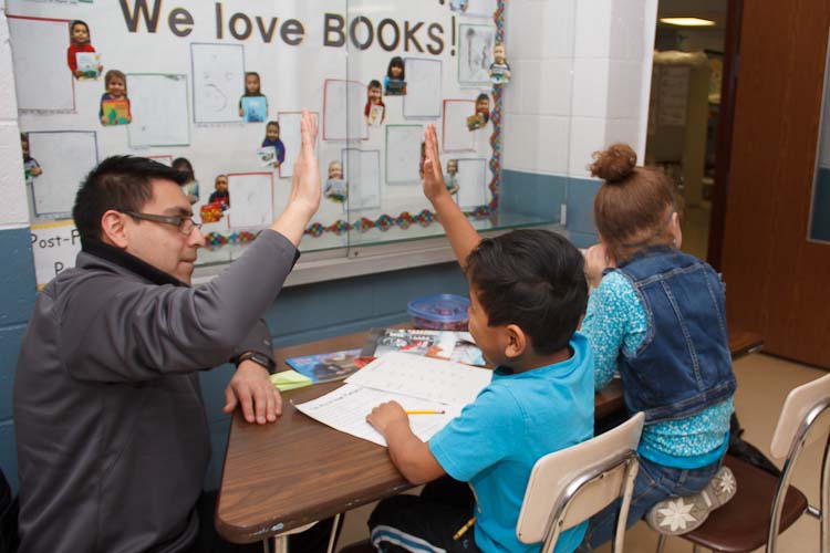 Israel Flores with reading buddies Tori and Joel  Photo by Susan Andress