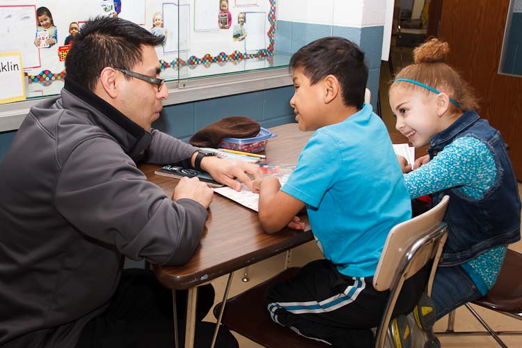 Israel Flores with reading buddies Tori and Joel  Photo by Susan Andress