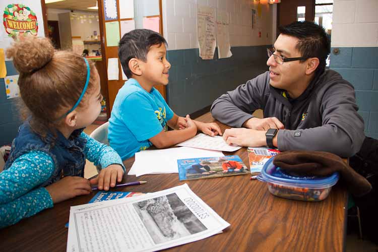 Israel Flores with reading buddies Tori and Joel  Photo by Susan Andress