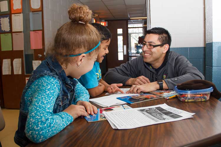 Israel Flores with reading buddies Tori and Joel  Photo by Susan Andress