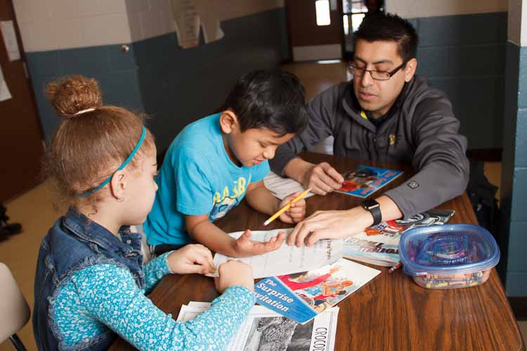 Israel Flores with reading buddies Tori and Joel  Photo by Susan Andress