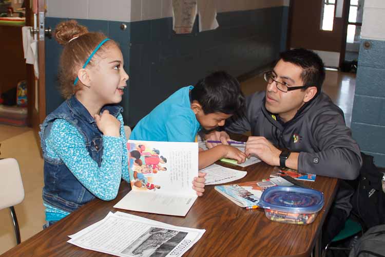 Israel Flores with reading buddies Tori and Joel  Photo by Susan Andress