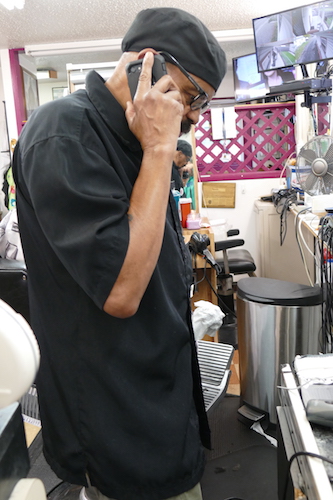 Tommy Henry takes a phone call during a busy afternoon at his shop.