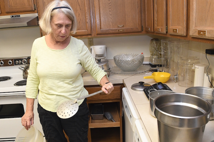 Janet Chichester sorts through kitchen equipment at the Trinity Neighborhood Center