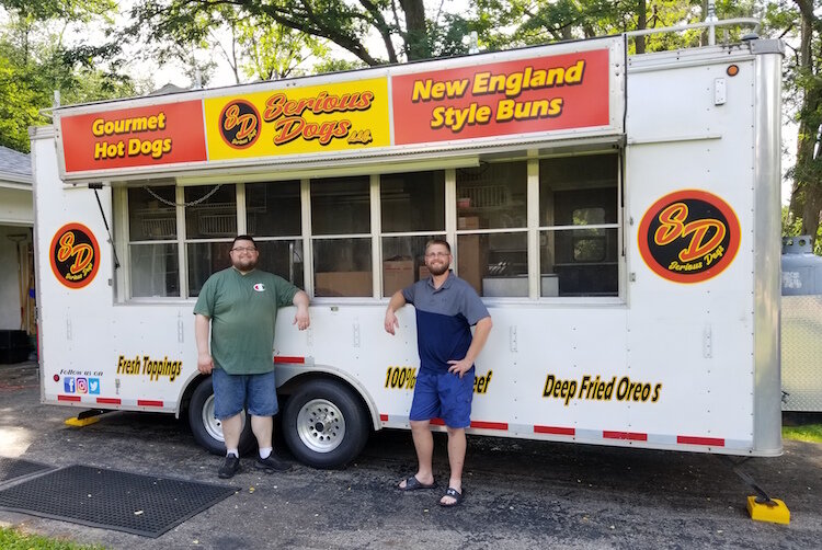 James Woodin, left, and his brother, Thomas, in front of their food trailer.