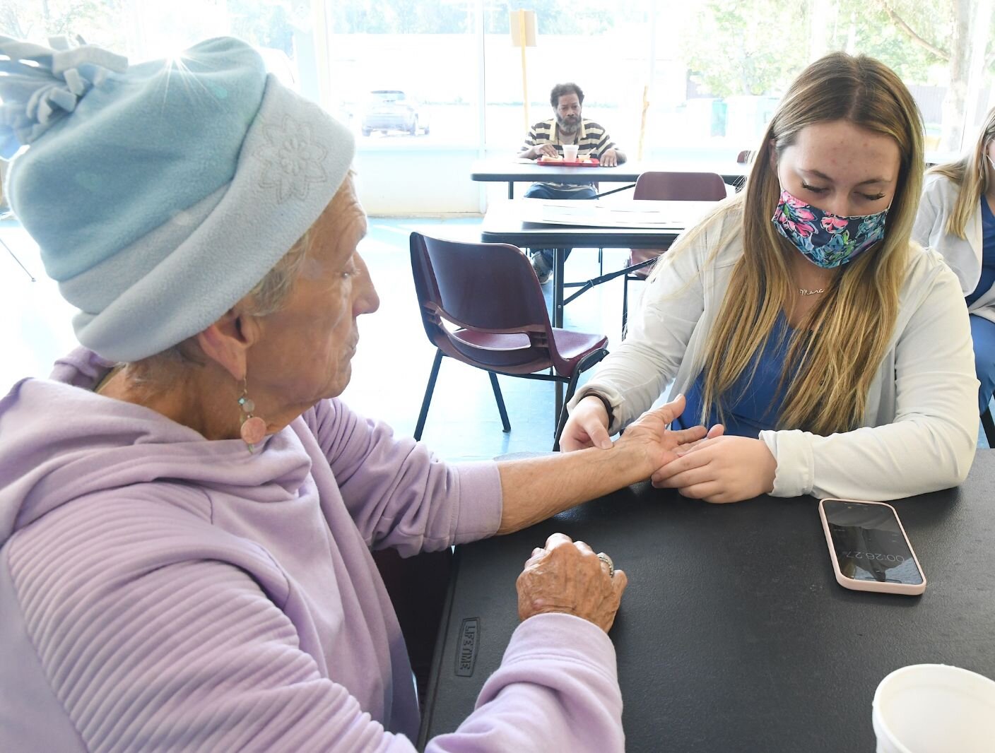 Marie Garner, left, has her vital signs checked by Paige Decker, a nursing student at Kellogg Community College, at the SHARE Center.