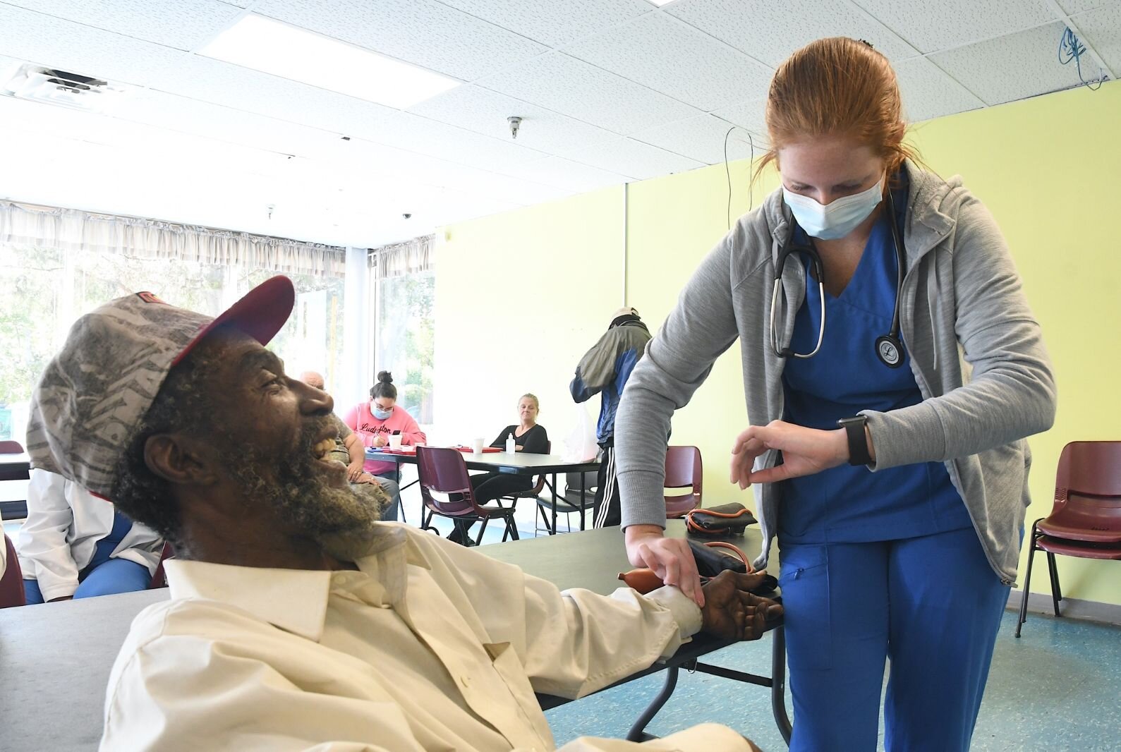 Nathaniel Porter, Jr. laughs as Hailey Davis, a nursing student at Kellogg Community College, checks his vital signs at the SHARE Center.