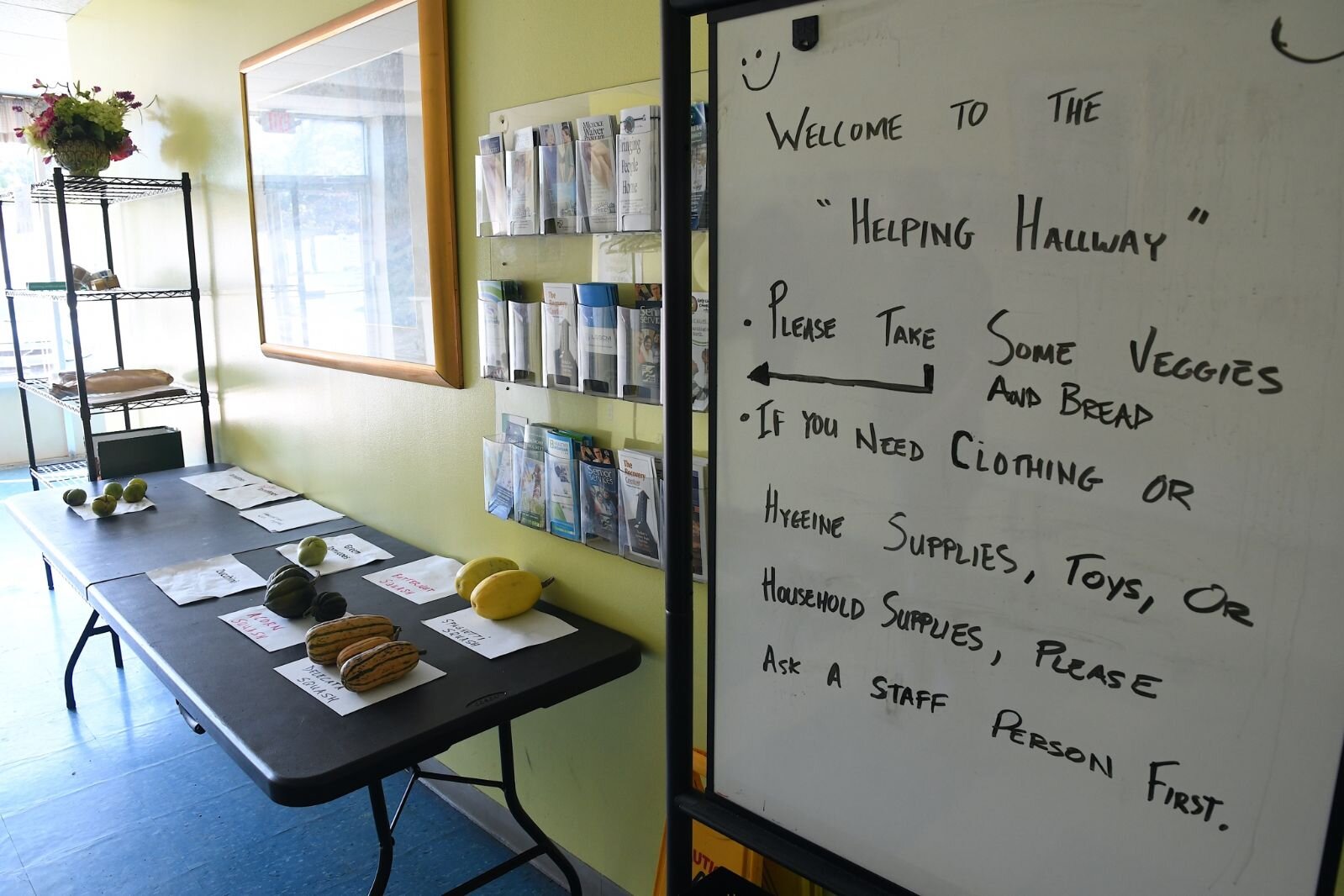 A sign  on a wall at the SHARE Center tells people to help themselves to items.