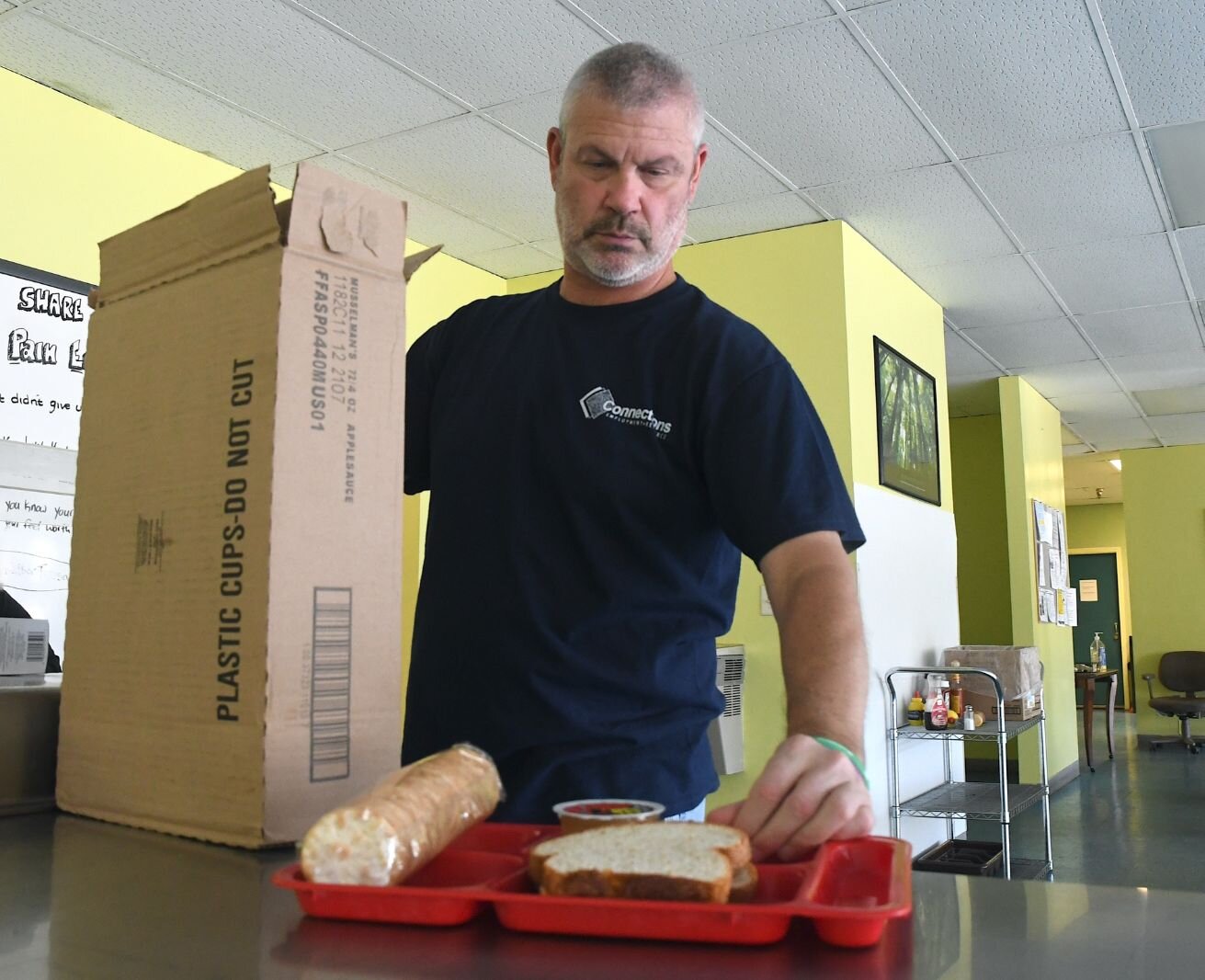 James Vannoty, team leader at the SHARE Center, arranges items for lunch.