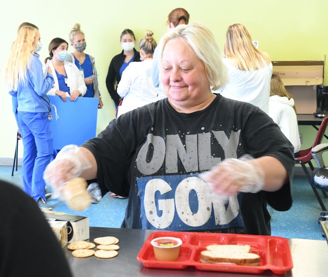 Sheri Adams, kitchen and laundry worker at the SHARE Center, serves lunch.