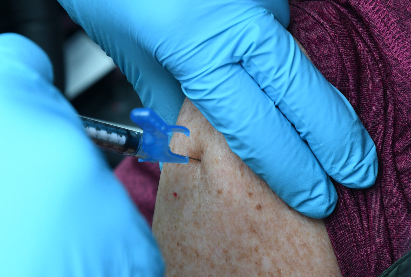 Under the skillful hands of a nurse, the first of two doses of the vaccine is administered to Lynn Corrigan, an employee with the Calhoun County Health Department.