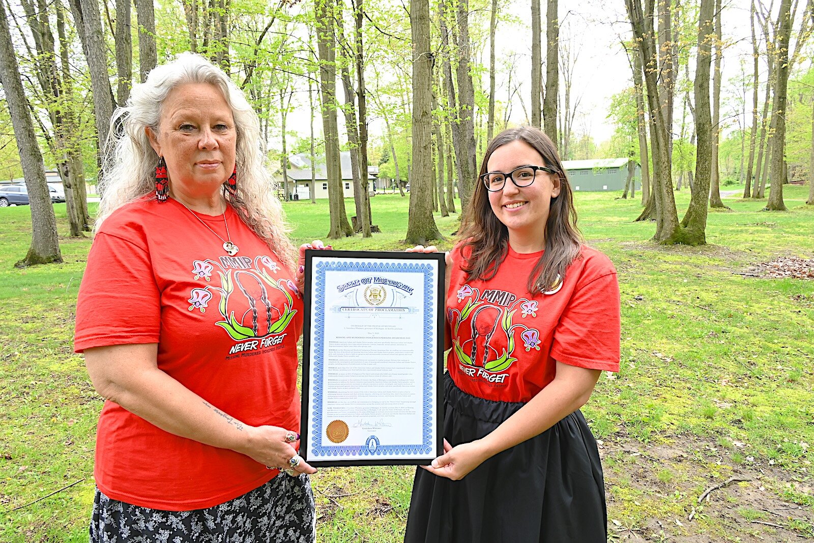 Robin Elkins, left, and Bianca Beerman, Tribal Council Coordinator, hold up a proclamation from Michigan Governor Gretchen Whitmer declaring May 5, 2025 as Missing and Murdered Indigenous Persons Awareness Day.