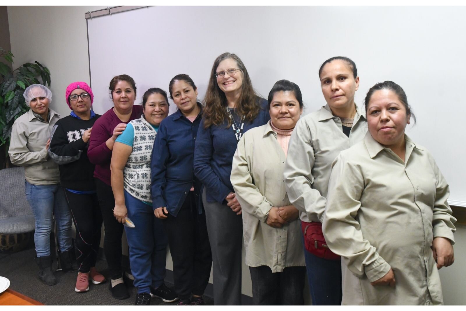 Posing for a photo Snackwerks employees who completed the “Workforce English as a New Language” course. Fifth from the right is Mary Okamoto of VOCES.