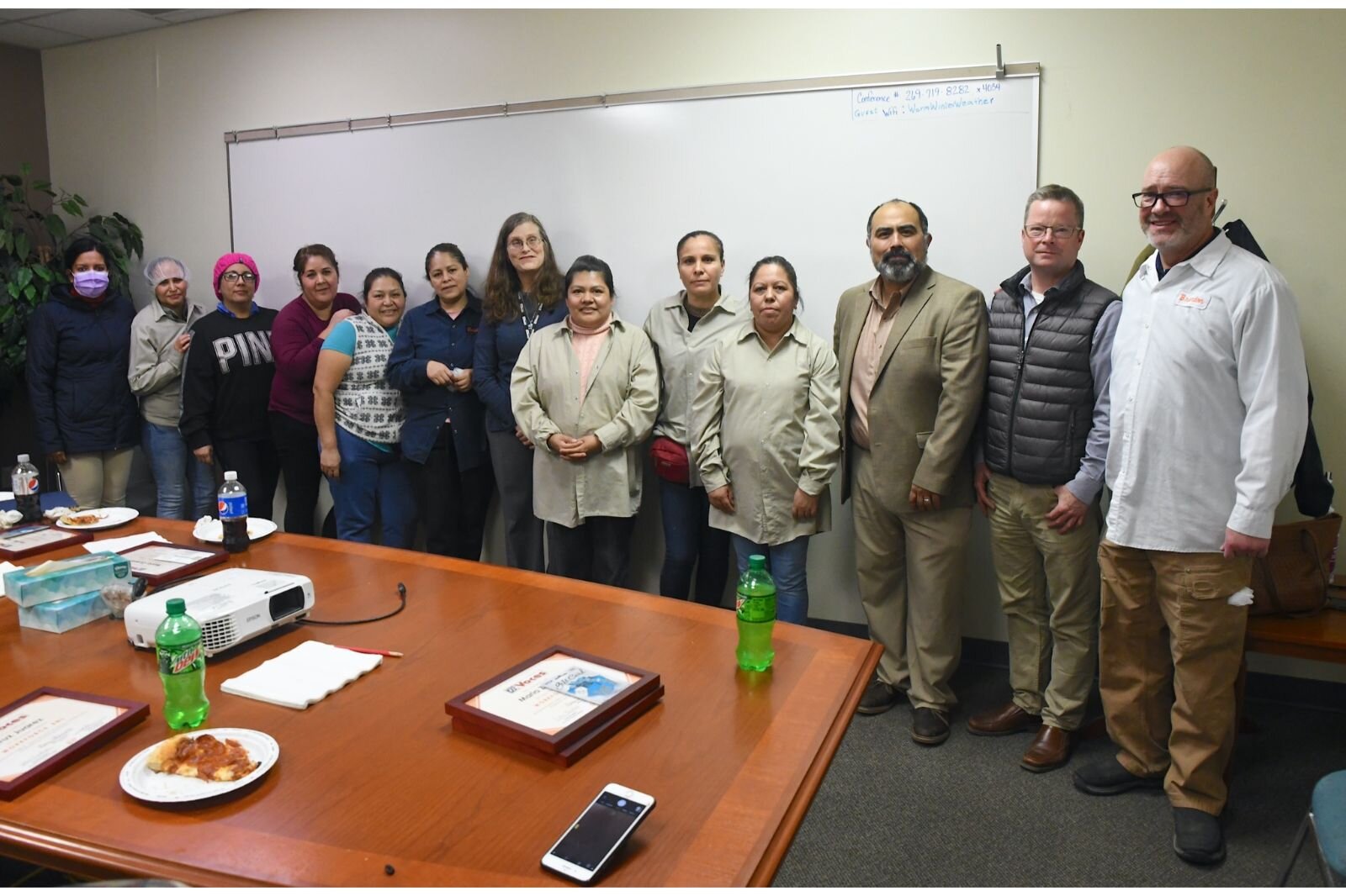 Posing for a photo Snackwerks employees who completed the “Workforce English as a New Language” course. Also seen are, Mary Okamoto of VOCES, in the middle, Jose Luis Orozco of VOCES, John Hart of the City of Battle Creek, Brandon of Snackwerks.