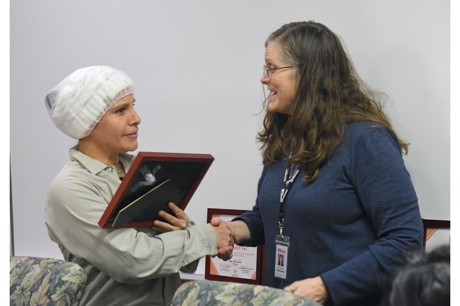 Snackwerks employee Cruz Juarez Escutia receives her certificate from Mary Okamoto of VOCES.