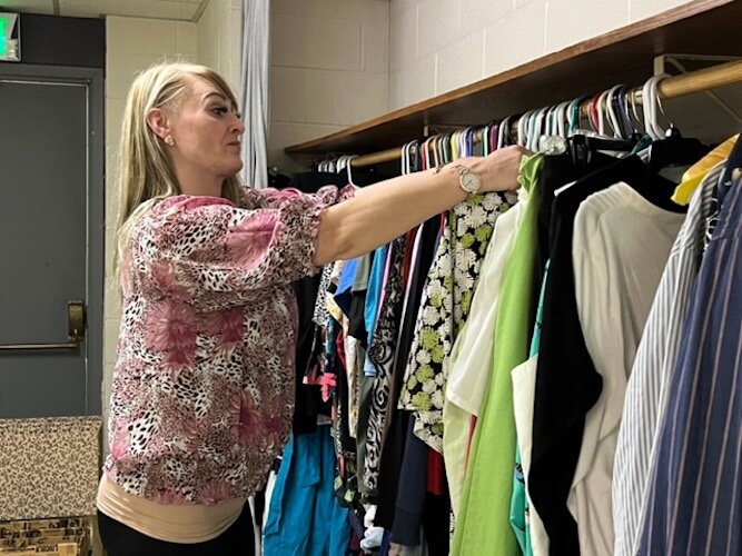  Stephanie McNeil organizes clothing at the Co-op's clothing closet.