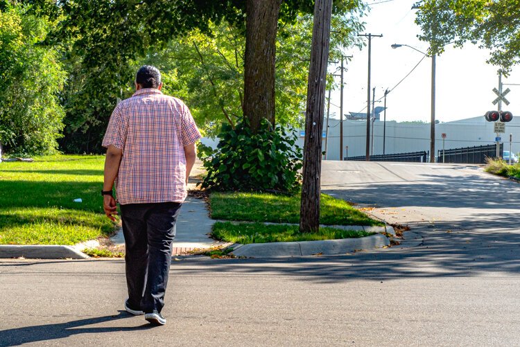 Tyler Dancer walking in his Northside neighborhood.