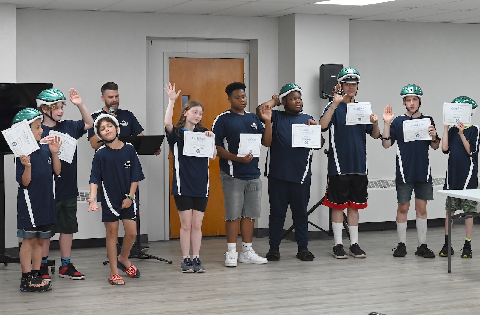 Students pose with their program graduation certificates.