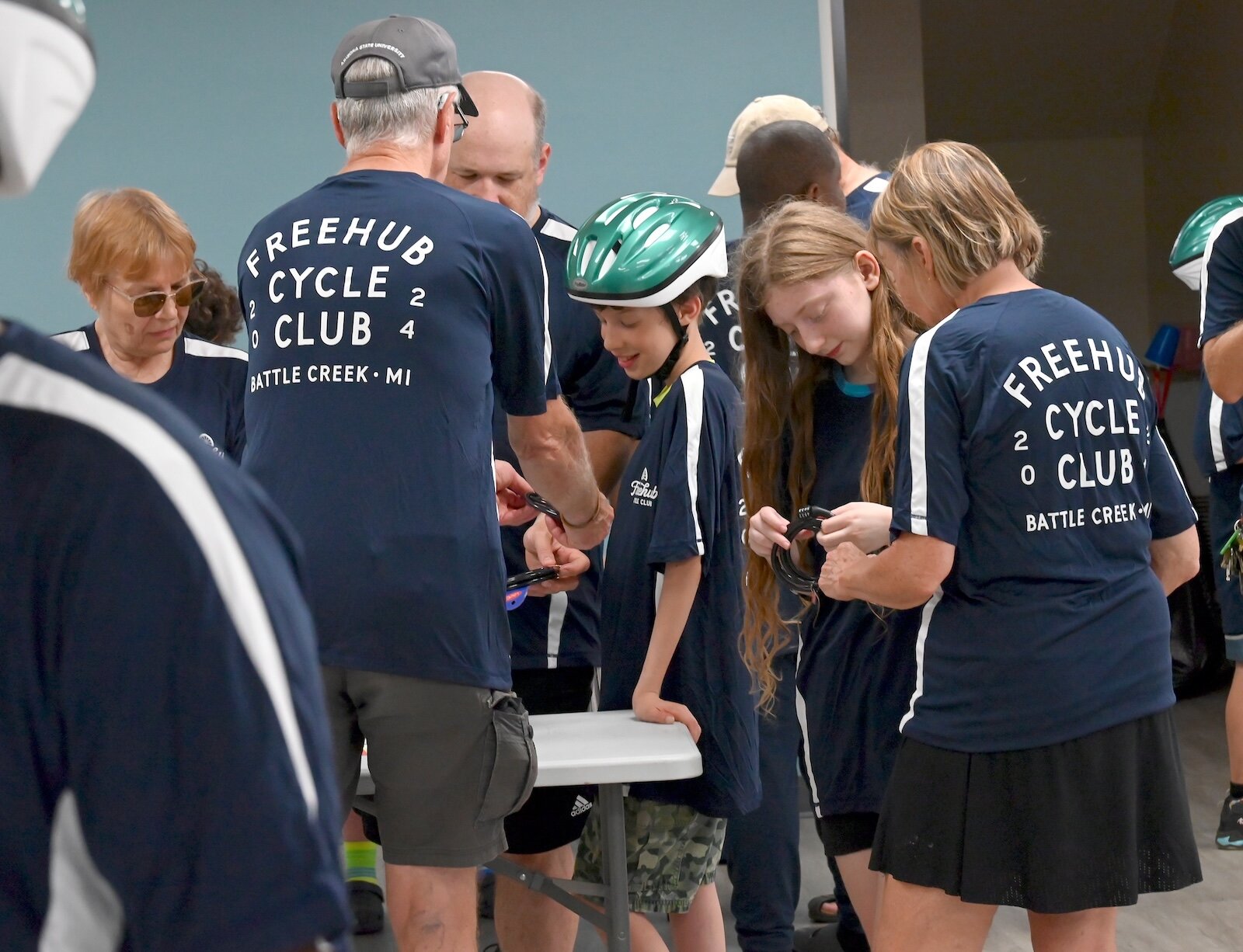 Youth who will be receiving bikes gather to learn how to use bicycle locks.