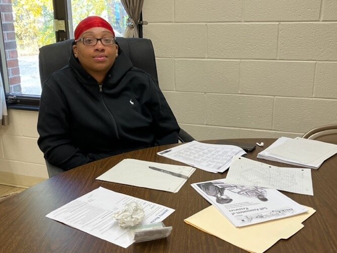 Taykiah Guy sits at a table where she studies to learn more about the Co-op in preparation for promoting the organization at Washington Heights United Methodist Church.