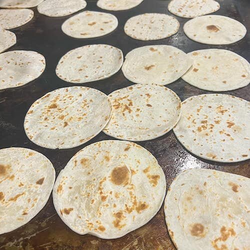 Tortillas on the grill at Dishes served at Torti Tacos.