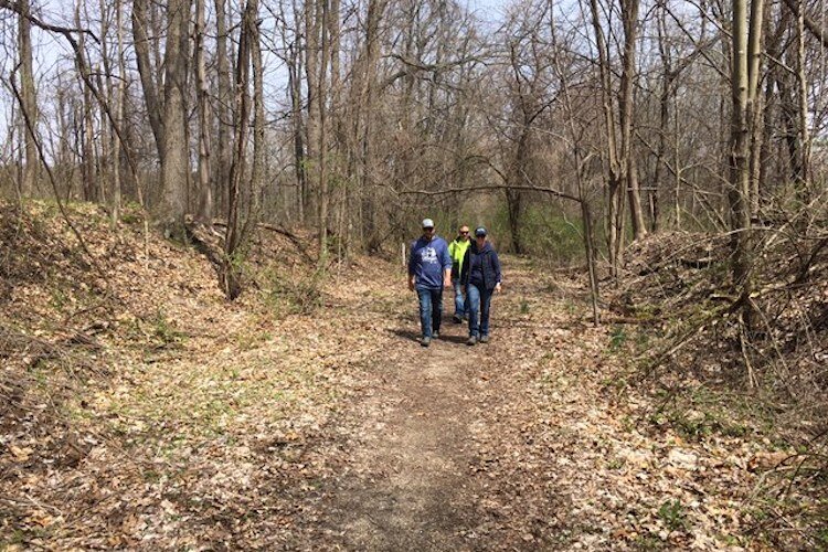 From left, Derek Nofs, Ryan Russell and  Nora Balgoyen walk along the corridor and discuss its possibilities. Photo courtesy Karen High, Oshtemo Parks.