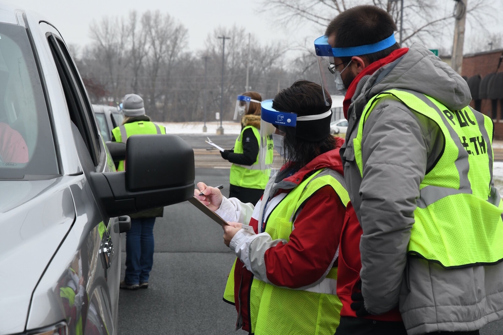 Calhoun County Health Department employees ask questions of people lined up then their vehicles prior to giving them a dose of Pfizer/BioNTech COVID-19 vaccine in Battle Creek Friday morning. 