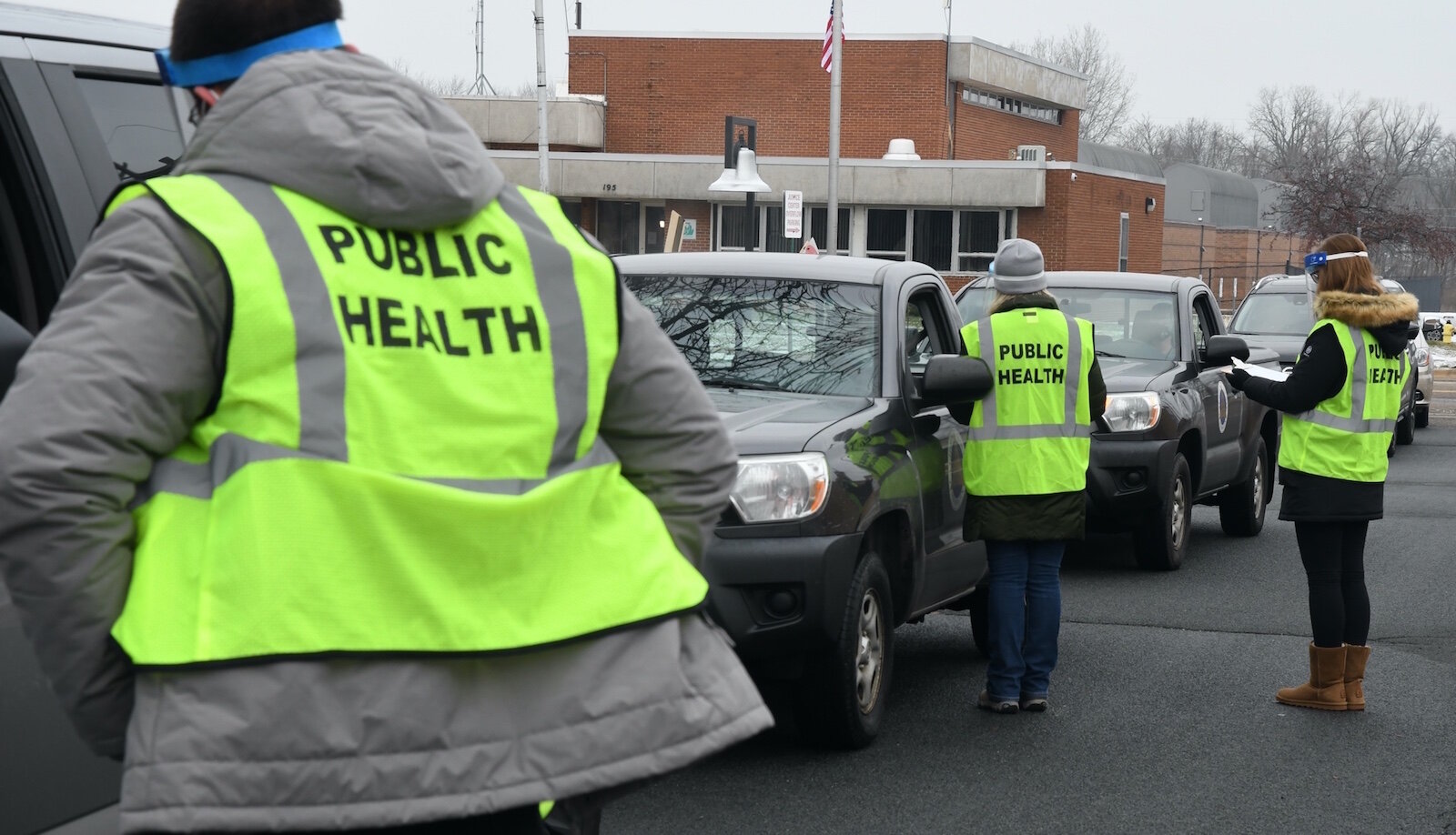 Calhoun County Health Department employees ask questions of people lined up then their vehicles prior to giving them a dose of Pfizer/BioNTech COVID-19 vaccine in Battle Creek Friday morning. 