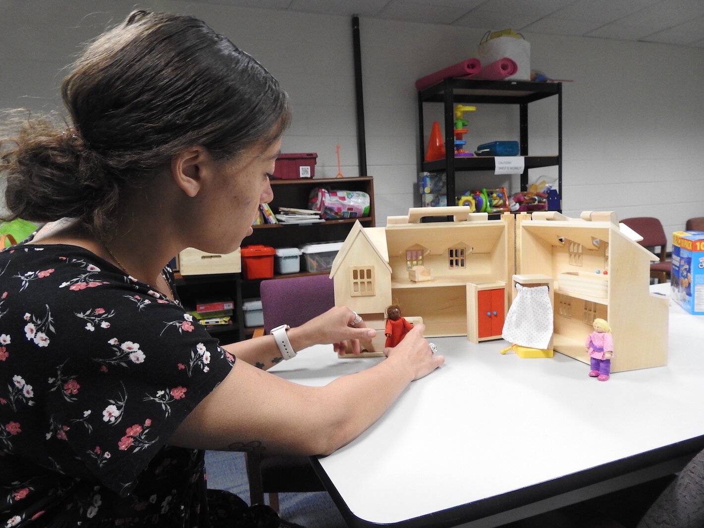 Victoria Orbe, children’s services director for Community Healing Centers in Kalamazoo, in May demonstrates toys counselors use to help children talk about trauma. Student loan debt assistance could equip more mental health workers to help struggling