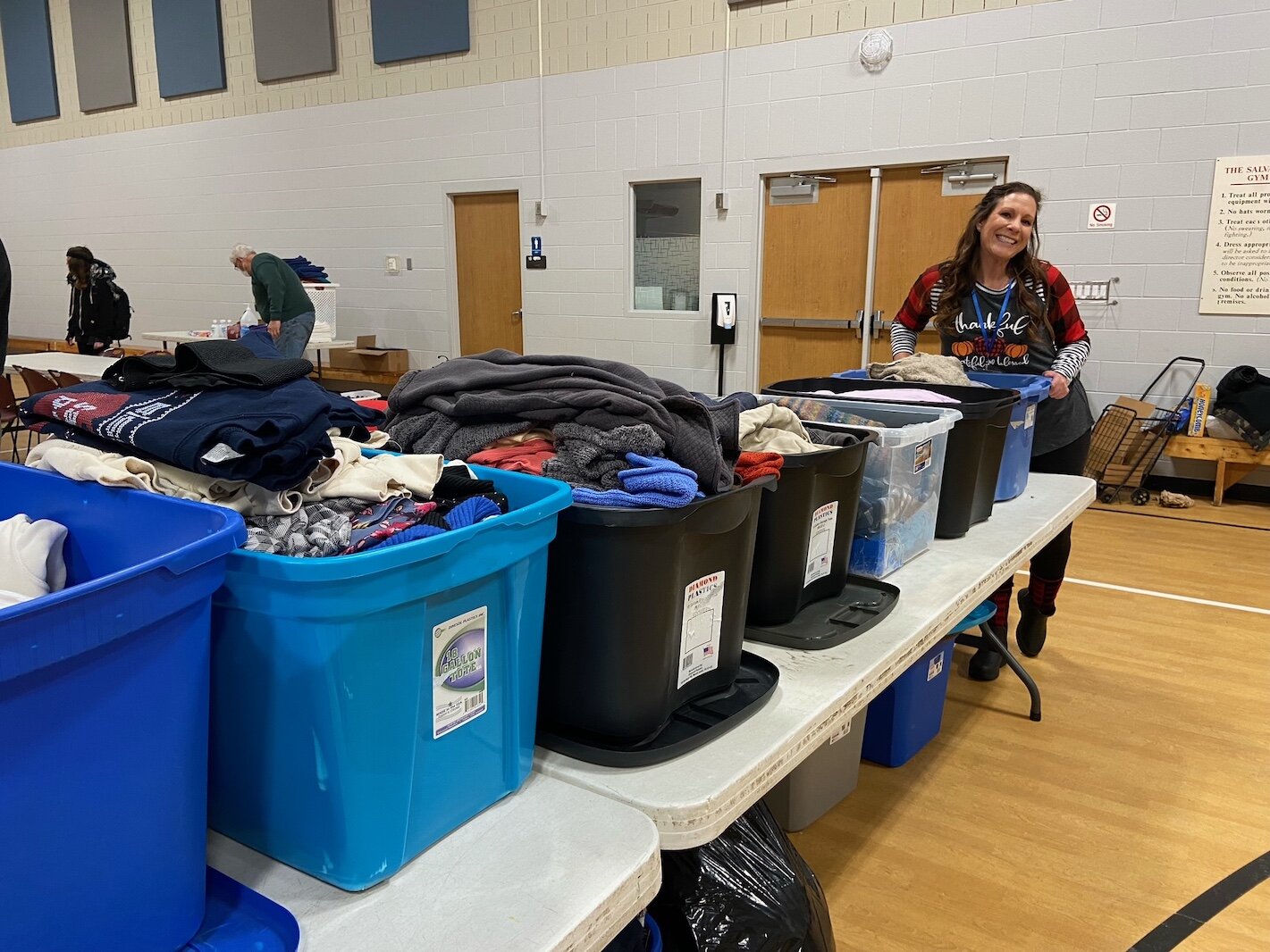 Tricia Meek, who helps organize donations and supplies, stands by bins of items to be supplied to those in need at the Community Warming Center.