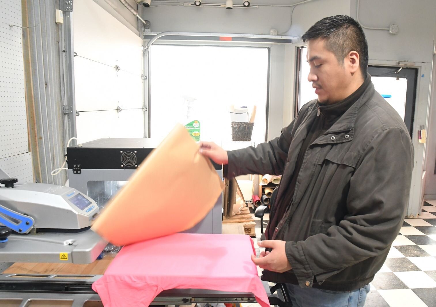 David Ninez of Hexxon Design Co. works on the printing of a shirt.