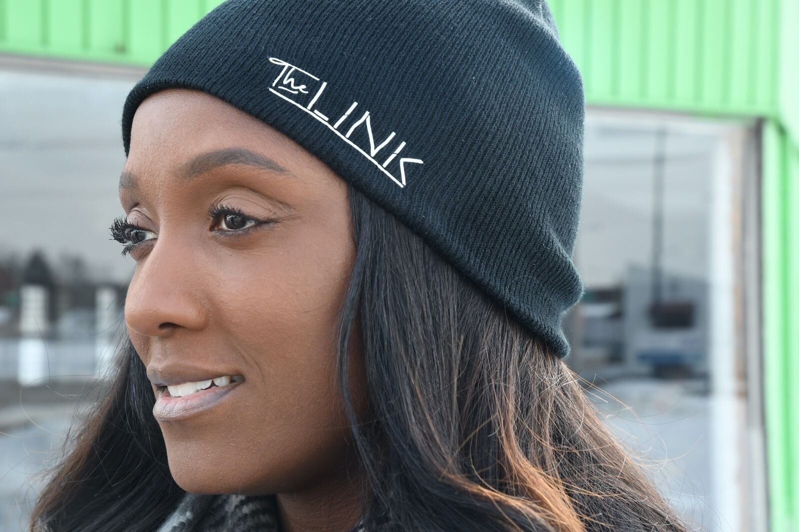 Tonesha Heath wears a knit hat bearing the logo for her business.