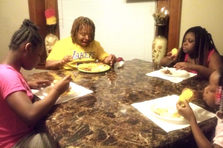 Michael Wilder sits at the head of the table to have dinner with his family on April 18, the first time the family had dinner together since he became ill with the coronavirus on March 14. At left is his wife Dominique. 