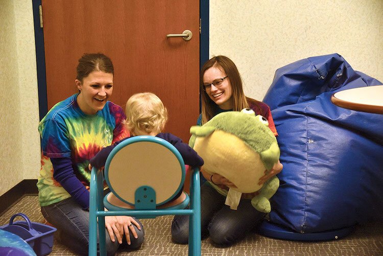  Gretchen Slenk, left, and Danielle Mott assess a young child for trauma. 