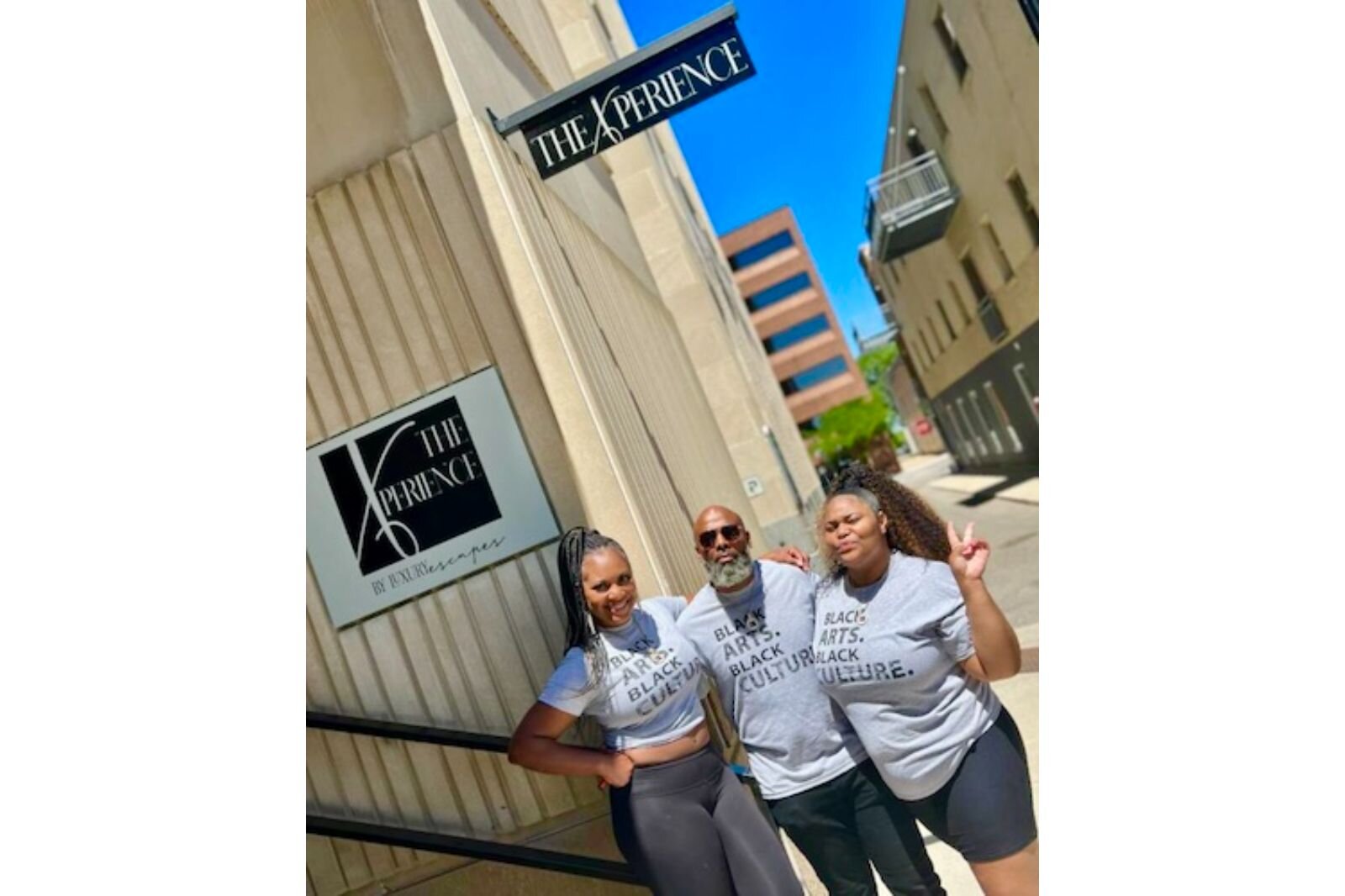 From left, Kim Guess, Bryan Sims, and Symphony Ollie stand outside the front entrance of The Xperience by Luxury Escape at 145 Farmers Alley in downtown Kalamazoo.