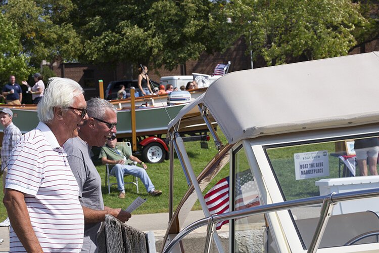 Boating enthusiasts check out a 30-foot, 1978 Chris Craft Roving Kind during the Boat the Blue Antique & Classic Boat Show on Saturday, Sept. 11.