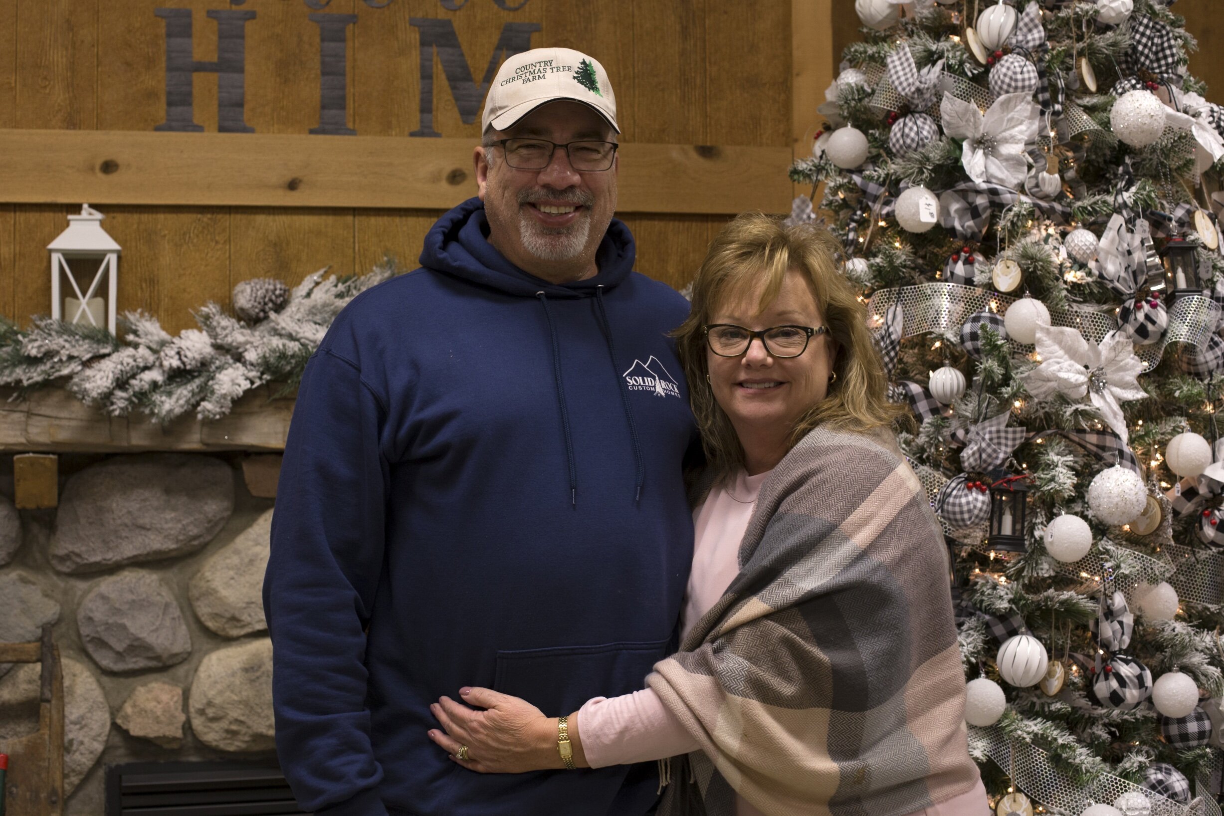 Country Christmas Tree Farm owners Ed and Theresa Shephard pose for a photo in front of the fireplace at the gift shop.
