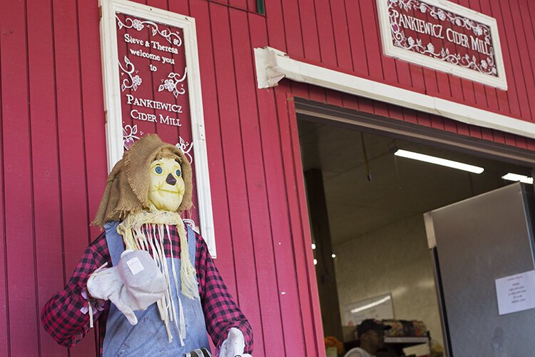 Mr. Cinnamon, also referred to as Mr. Cinnaman, stands welcoming customers at the market's entrance.