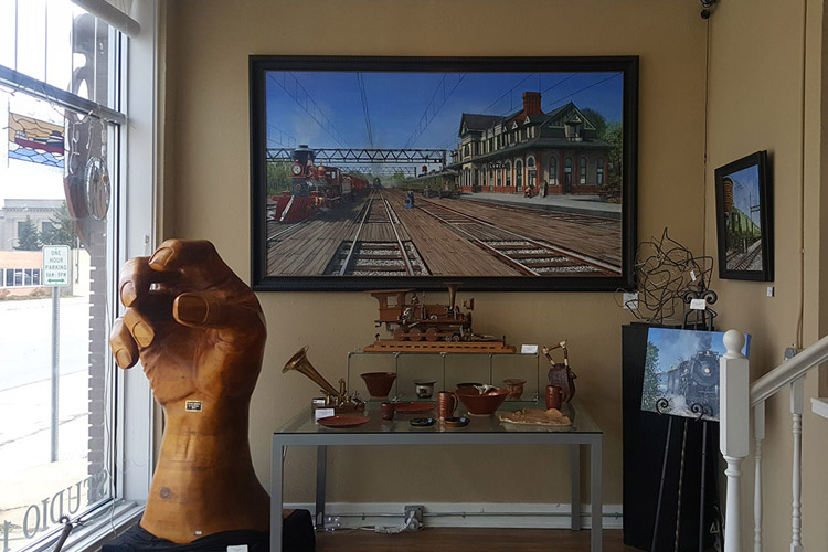 Wood sculpture and paintings in the front room gallery at Studio 1219.